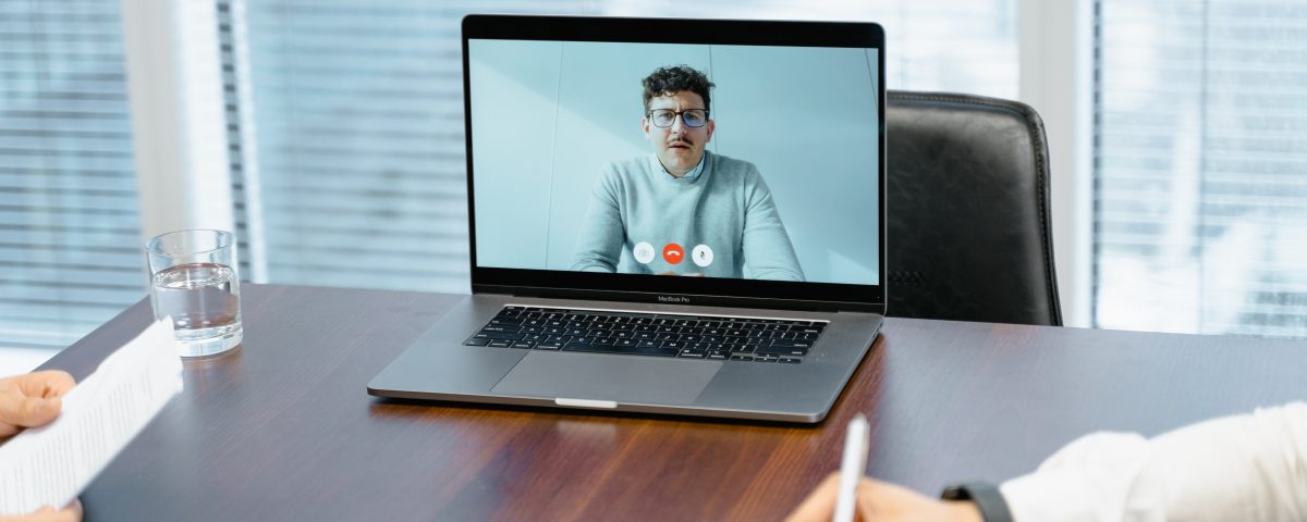 Modern coworking space with a video call on a laptop, ideal for hybrid work environments.